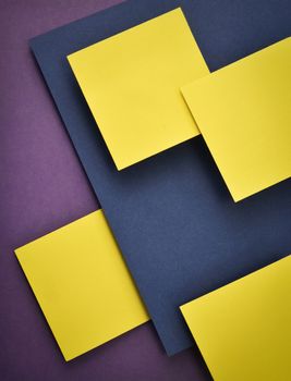 Yellow squares of tissue paper on a abstract dark background