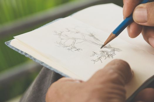 man writing a tree on sketchbook,Environment Conservative concept