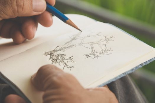 man writing a tree on sketchbook,Environment Conservative concept