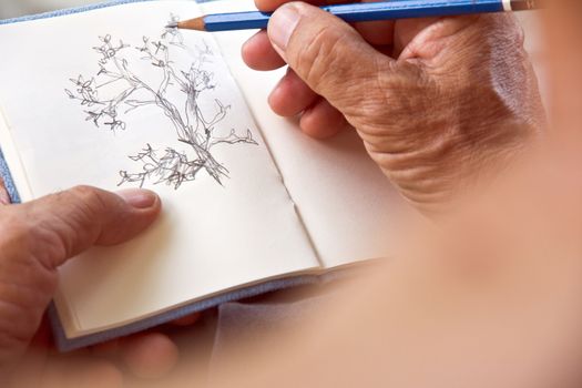 man writing a tree on sketchbook,Environment Conservative concept