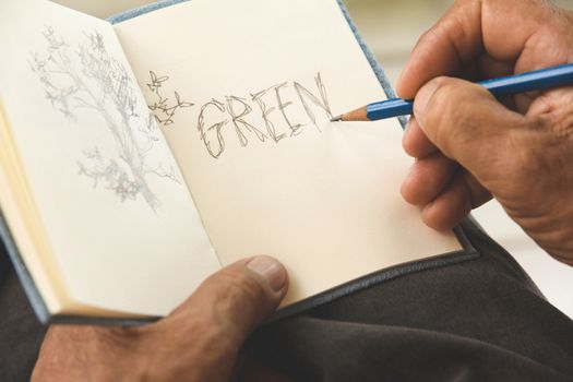 man writing a tree on sketchbook,Environment Conservative concept