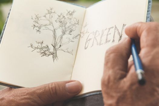 man writing a tree on sketchbook,Environment Conservative concept