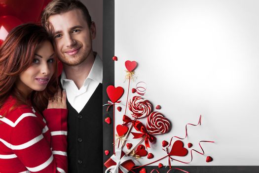 Happy couple posing with Valentine's day decoration with white copy space