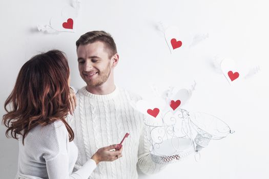 Young couple with winged hearts flying from the cage, Valentines day concept