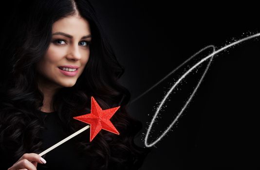 Woman with star shaped magic wand and sparks