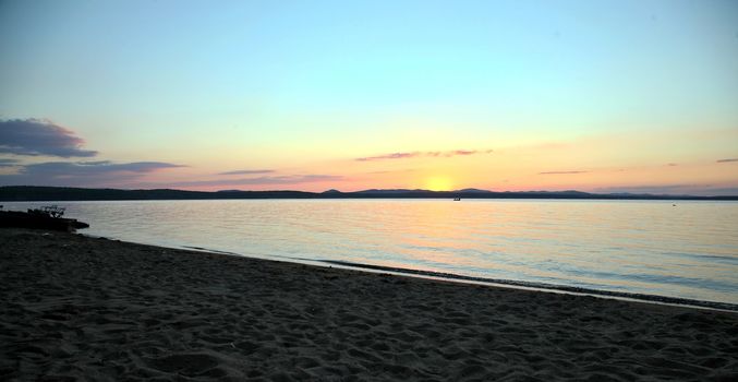Blurred silhouette, the shore of lake over sunset in background. Beautiful landscape. sunset Image selective focus at lake.