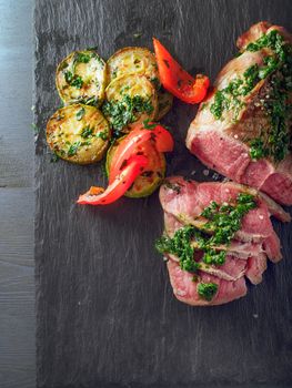 Roast Beef dinner with roasted zucchini, pepper and salsa verde.