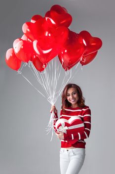 Woman with heart shaped balloons and gift, Valentines day
