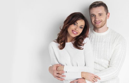 Portrait of young smiling couple in white