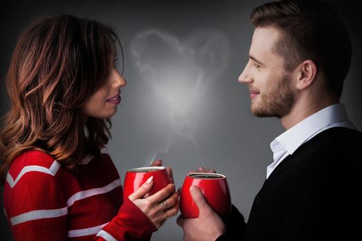 Young couple holding coffee mags with heart shaped steam, Valentine's day concept