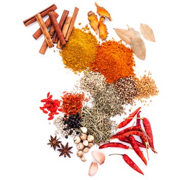 Assorted of spices black pepper ,white pepper,fenugreek,cumin ,bay leaf ,cinnamon stick,thyme,goji berry,safflower,rosemary curry powder ,chilli and fennel seeds isolated on white background. Assorted of spices  flat lay on white background. 