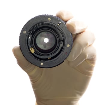 Lens camera in his hand, a hand in a white glove on a white background