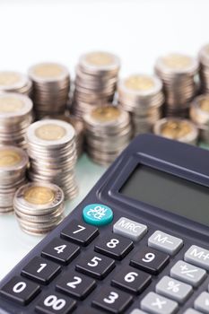 counting income, pile of money, calculator in white background