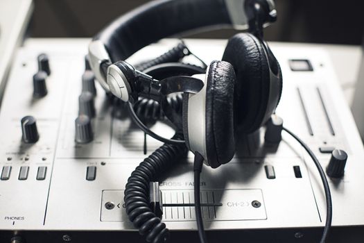 DJ mixer and headphones with a vinyl record, close up.