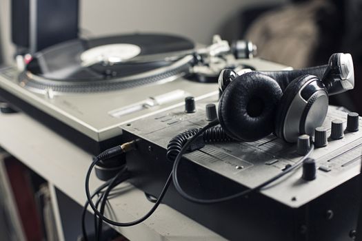 DJ mixer and headphones with a vinyl record, close up.