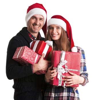 Happy couple in santa hats holding christmas gift boxes isolated on white background