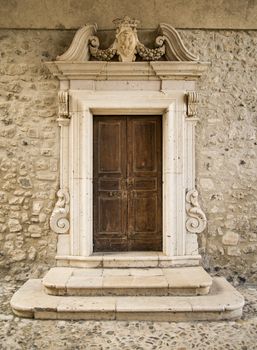 The entrance wooden door in an old Italian house