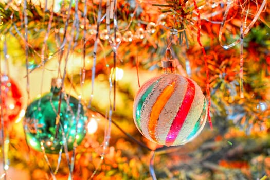 Shiny christmas ornamental ball hangs on christmas tree.