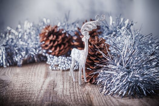 Home decor pine cones  and white deer on a wooden background. 