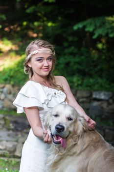 beautiful girl in white dress with a white dog in the garden