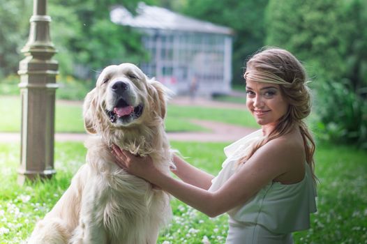 beautiful girl in white dress with a white dog in the garden