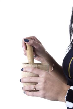 Wooden mortar in female hands on a white background