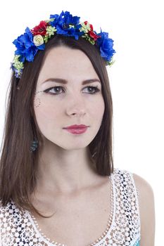 Portrait of a girl in a wreath of flowers on a white background