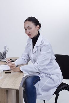 Young female doctor working at his desk