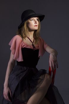 Portrait of a young woman in a hat on a black background