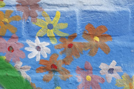 Blue Bricks and painted Flowers  in a  brick Wall
