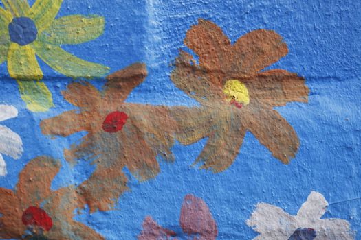 Blue Bricks and painted Flowers  in a  brick Wall