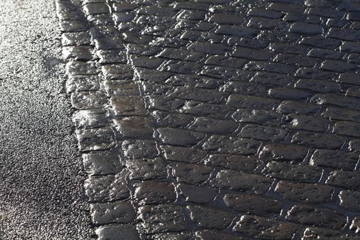 wet glittering paving stones on street