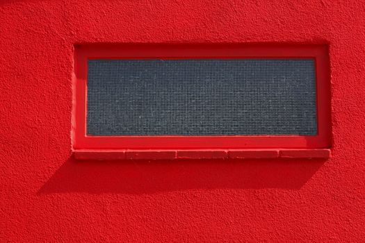 basement windows on a red house wall