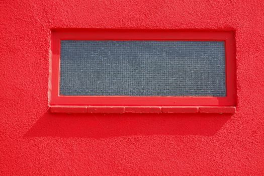 basement windows on a red house wall