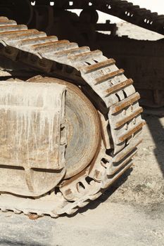 Muddy Chain Weels of an Excavator in the Sand