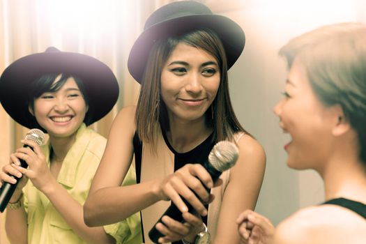 portrait group of asian young woman singing a song in caraoke entertainment room  with happiness emotion and joyful happy face
