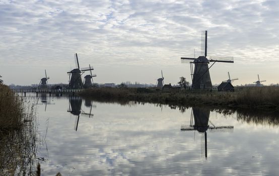 UNESCO World Heritage group of windmills in Kinderdijk in Holland europe, windmills at the water with reflection and twilight
