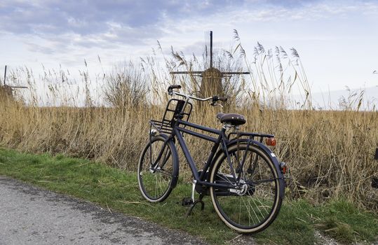 black old type bike with dutch windmill as background