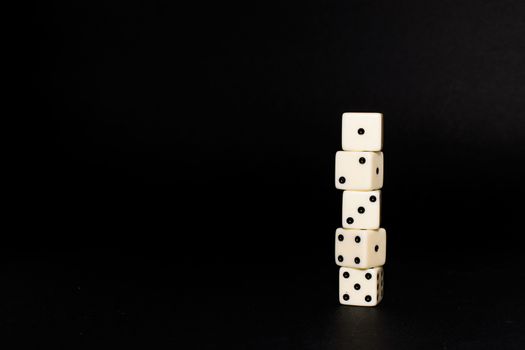 Five dice disposed in vertical position on a black background