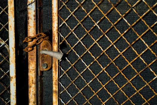 Old closed door with rust and a chain