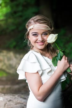 beautiful girl with a white rose in the Park on the grass