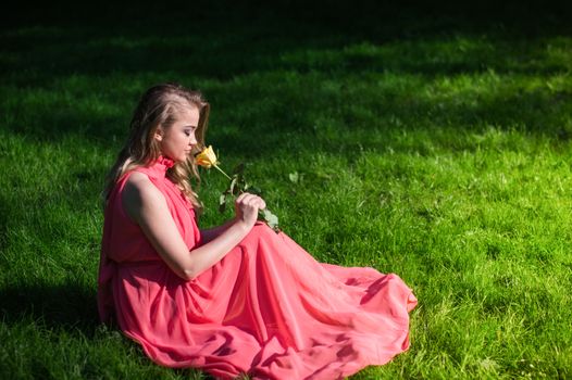 beautiful girl sniffing white rose in the Park