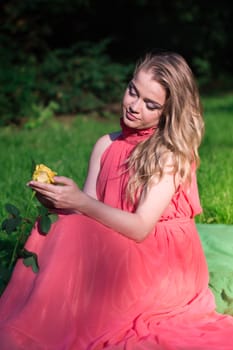 beautiful girl with a white rose in the Park on the grass