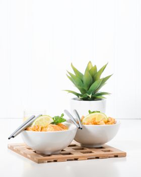 Two bowls of delicious chicken pad thai with lime.