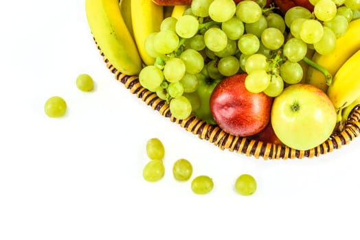 Overhead shot of the basket full of fruit and scattered grapes