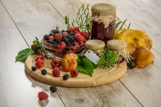 Traditional homemade preserves in vintage style. Jars of jam with fruits and mushrooms on a wooden table.