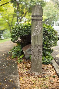 Wooden pole with text canning walk in park, Singapore