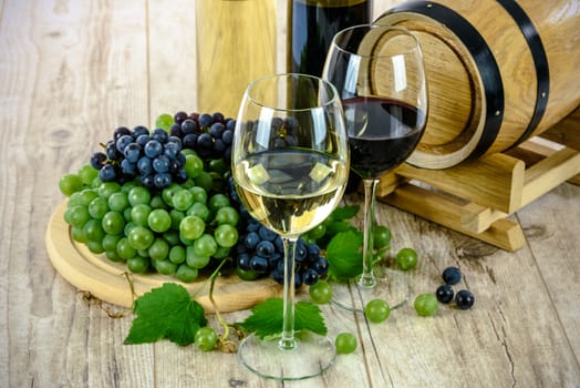 Two types of grape wine and wooden barrel on a wooden vintage table