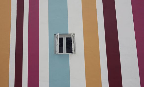 Colorful striped wall with window. Concept for background, exterior