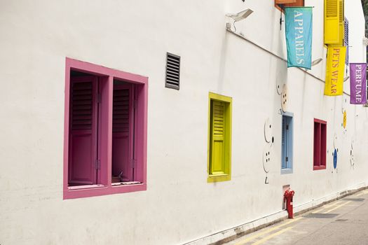 White wall with colorful windows. Concept for background, exterior